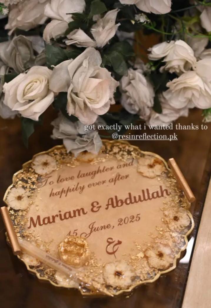 Decorative wedding invitation with flowers and text on a wooden surface